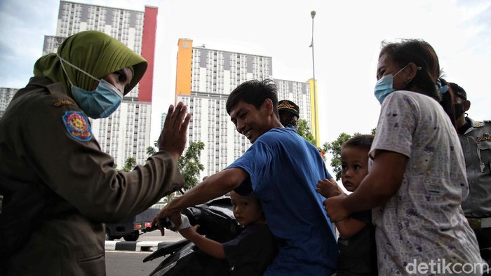 Kasus Harian COVID-19 di Jakarta Masih Tertinggi Petugas Satpol PP melakukan operasi tertib masker di kawasan depan Rumah Sakit Darurat COVID-19 Wisma Atlet Kemayoran, Jakarta Pusat, Selasa (15/19).
