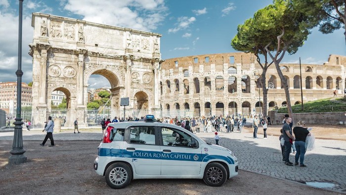 Rome, Italy - October 3, 2019: a police car in front of the Arch of Constantine near the Colosseum or Coliseum.