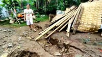 Warga menunjukkan retakan yang diakibatkan oleh pergerakan tanah.