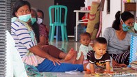 Beberapa warga berkumpul dengan duduk lesehan di lokasi pengungsian.