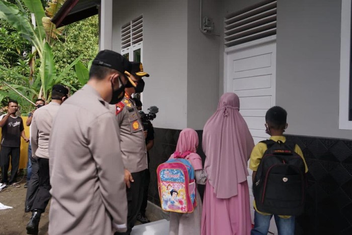 Buruh cuci di Aceh saat menerima kunci rumahnya yang telah direnovasi oleh polisi