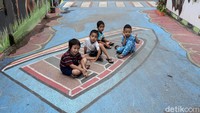 Tak jarang mural di kawasan itu menjadi tempat bermain anak-anak yang tinggal di area tersebut.