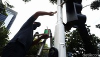 Petugas dari Dinas Perhubungan (Dishub) DKI Jakarta, melakukan perawatan tiang lampu pengatur lalu lintas, di Jalan Medan Merdeka Selatan, Jakarta, Rabu (16/12/2021).
