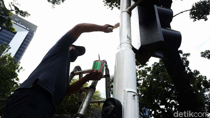 Dinas Perhubungan (Dishub) DKI Jakarta, melakukan perawatan tiang lampu pengatur lalu lintas, di Jalan Medan Merdeka Selatan, Jakarta. Tiang lampu tersebut dicat ulang.