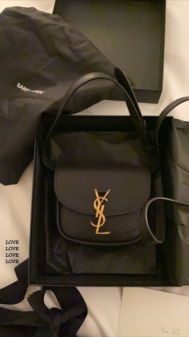 Dalam kesempatan lain, Rose Blackpink diberikan tas selempang hitam dengan logo ikonik YSL. Foto: Instagram @roses_are_rosie