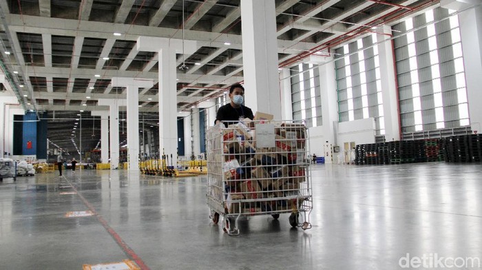 Vice President - Country Head of Business Functions Lazada Michael Willy Roosevelt (tengah) menceritakan tentang proses pengantaran dan juga pengiriman barang di gudang Lazada, Cimanggis, Depok, Jawa Barat, Kamis (17/12). Gudang penyimpanan berukuran besar ini menjadi pusat distribusi pengantaran dan juga pengiriman barang dari berbagai daerah di Indonesia