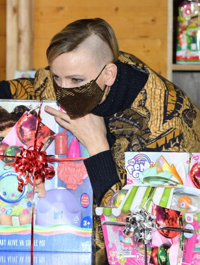 Putri Charlene melengkapi penampilannya dengan masker berhias sequin warna emas. Dia juga mengenakan anting bulat. Foto: Getty Images