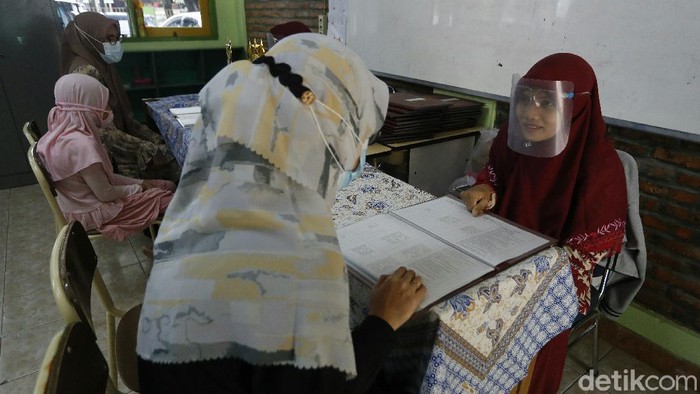 Sebagai bentuk pencegahan penyebaran virus COVID-19, pihak guru di  SD Daar El-Salam, Kabupaten Bogor, Jawa Barat, Kamis (17/12/2020), menerapkan protokol kesehatan yang ketat saat pembagian raport kenaikan kelas.