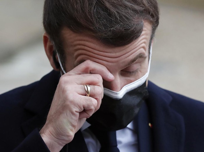 French President Emmanuel Macron reacts as he listen to the speech of Portuguese Prime Minister Antonio Costa, Wednesday, Dec. 16, 2020 in Paris. French President Emmanuel Macron has tested positive for COVID-19, the presidential Elysee Palace announced on Thursday. (AP Photo/Francois Mori)