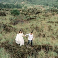 Pasangan yang satu ini juga berpose di tengah padang rumput dan perbukitan. Keduanya tampak serasi dengan pakaian berwarna putih. Foto: Instagram/@kalinaocktaranny