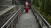 Seorang warga mengenakan kostum Santa Claus saat akan membagikan kopi di kawasan Sudirman, Jakarta, Jumat (18/12/2020).