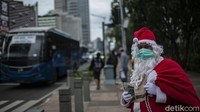 Santa Claus itu berjalan kaki di tengah kepadatan aktivitas Ibu Kota untuk membagikan kopi gratis.