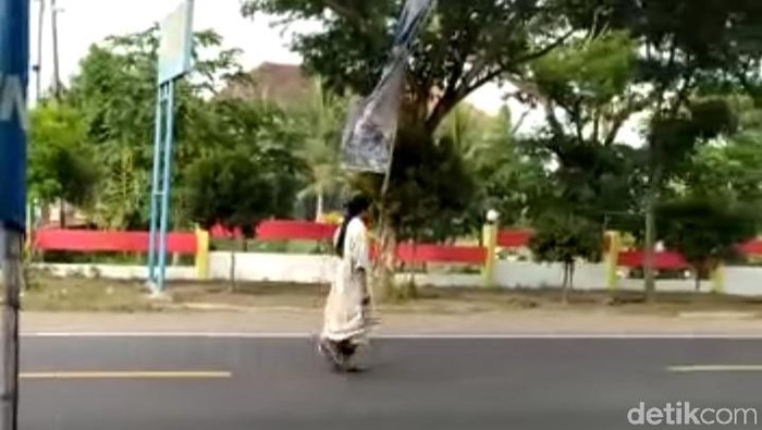 Sebelum Salat di Jalan, Pria Bergamis Ini Berjalan antara Lalu Lalang Kendaraan