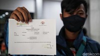 Seorang penumpang kereta menunjukkan hasil pemeriksaan rapid test di Stasiun Pasar Senen, Jakarta, Jumat (18/12/2020).