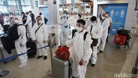 Tampak sejumlah penumpang tujuang Kunming, China mengenakan alat pelindung diri seperti baju hazmat dan kacamata serta masker.