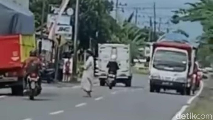 Video Seorang Pria Bergamis Salat di Tengah Jalan Raya Viral
