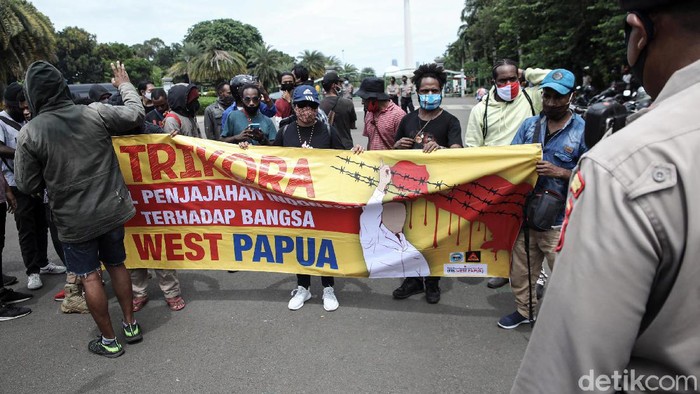 Aksi Memperingati Operasi Trikora di Monas Dibubarkan Masyarakat Papua melakukan aksi memperingati operasi Trikora 19 Desember 1961 di Patung Kuda, Medan Merdeka Barat, Jakarta, Sabtu (19/12/2020). Dalam aksi tersebut mereka menuntut 15 isu besar salah satunya Hentikan segala bentuk diskriminasi dan intimidasi terhadap mahasiswa Papua Barat di Indonesia dan Hentikan rasialisme dan politik rasial.