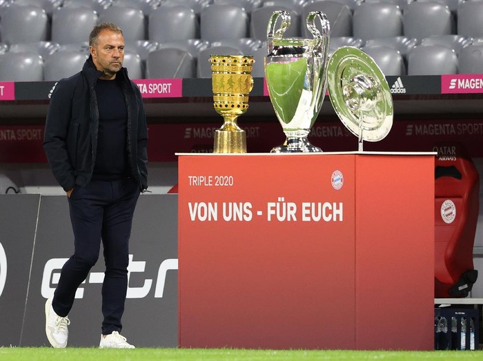 MUNICH, GERMANY - SEPTEMBER 18: Hans-Dieter Flick, head coach of Munich walks next to the German Cup winners trophy, the Championsleague winners trophy and the German Championship trophy prior to the Bundesliga match between FC Bayern Muenchen and FC Schalke 04 at Allianz Arena on September 18, 2020 in Munich, Germany. (Photo by Alexander Hassenstein/Bongarts/Getty Images)