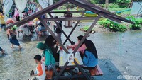 Puluhan meja kayu bercorak etnik dan minimalis ditata di tengah kolam air berkedalaman semata kaki. Sambil duduk makan, wisatawan bisa ongkang - ongkang bermain air.