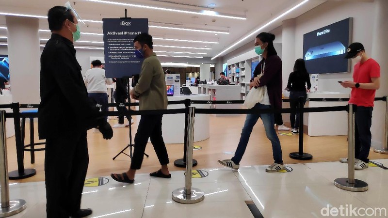 Warga mengantre untuk masuk ke Tenant Ibox kawasan Mall Senayan City, Jakarta Selatan, Sabtu (19/12). Sejak rilis penjualan perdana IPhone 12 di Indonesia pada Jumat kemarin (18/12), tampak di hari kedua ini pengunjung cenderung cukup ramai untuk melihat dan membeli IPhone 12.