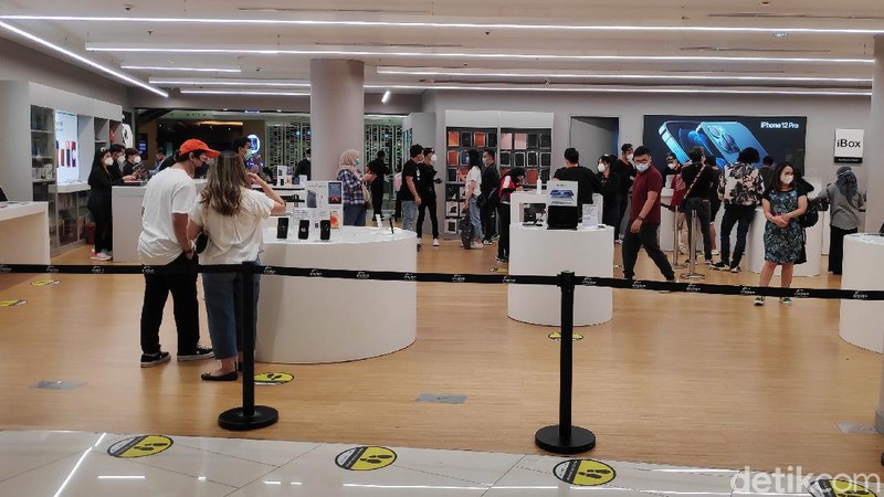 Warga mengantre untuk masuk ke Tenant Ibox kawasan Mall Senayan City, Jakarta Selatan, Sabtu (19/12). Sejak rilis penjualan perdana IPhone 12 di Indonesia pada Jumat kemarin (18/12), tampak di hari kedua ini pengunjung cenderung cukup ramai untuk melihat dan membeli IPhone 12.