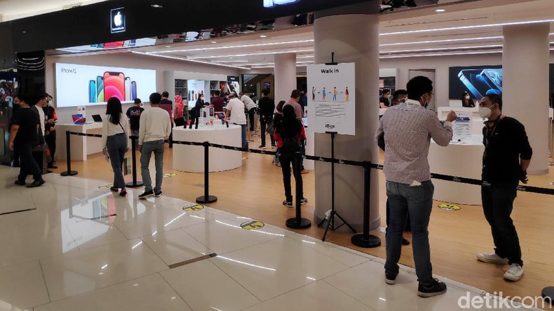 Warga mengantre untuk masuk ke Tenant Ibox kawasan Mall Senayan City, Jakarta Selatan, Sabtu (19/12). Sejak rilis penjualan perdana IPhone 12 di Indonesia pada Jumat kemarin (18/12), tampak di hari kedua ini pengunjung cenderung cukup ramai untuk melihat dan membeli IPhone 12.