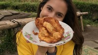Bukan di kafe cozy, Pevita menghabiskan sore dengan santai sambil duduk di bale bambu. Di sekitarnya terhampar kebun jagung super luas. Asyiknya lagi, ia sambil makan gorengan.  Foto: Instagram @pevpearce