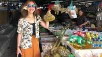 Dengan kacamata hitam dan bunga cantik di telinganya,  Pevita masih tampak jalan-jalan seru di pasar tradisional. Ia bahkan memegang sekantung kacang tanah.  Foto: Instagram @pevpearce