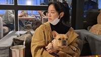 Kim Sejeong tampaknya juga menyayangi binatang, terutama anjing. Ini momennya saat berada di kafe bersama anjing yang ia peluk. Foto: Instagram @clean_0828