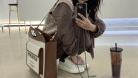 Menunjukkan gaya OOTD-nya, Sejeong tampil cantik dengan balutan dress dam tas cokelat. Ia juga sedang menikmati segelas Iced Americano. Foto: Instagram @clean_0828