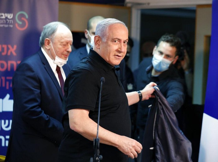 PM Israel Benjamin Netanyahu disuntik vaksin Pfizer-BioNTech. Ia dan Menteri Kesehatan Israel diketahu jadi yang pertama disuntik vaksin COVID-19 di negara itu.