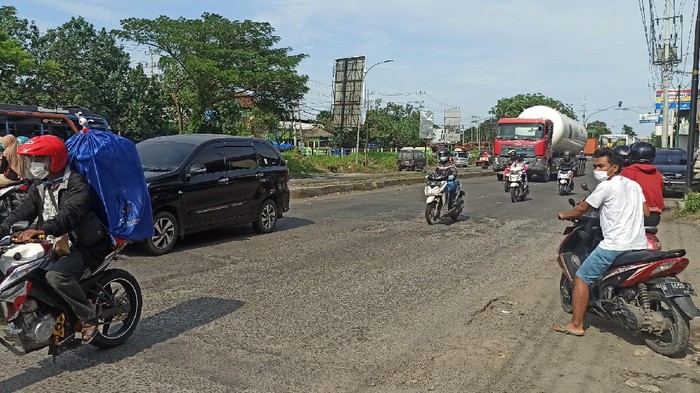 Ruas Jalan Pantura Demak KM 9 yang banyak ditemukan lubang. Petugas tampak memperbaiki sejumlah ruas jalan rusak tersebut, Minggu (20/12/2020)