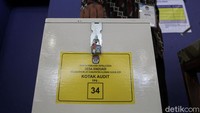 Warga memaksukan lembar kertas yang tercetak ke dalam kotak audit sesudah melakukan proses pemberian suara di Bilik Nunul 