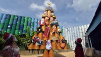 Pengunjung mengamati pohon Natal berbahan drum bekas di Kebon Vintage Cars Bali, Denpasar, Bali. Tempat rekreasi yang terdampak COVID-19 tersebut membuat dua pohon Natal berbahan drum bekas untuk menyambut Hari Raya Natal. ANTARA FOTO/Nyoman Hendra Wibowo