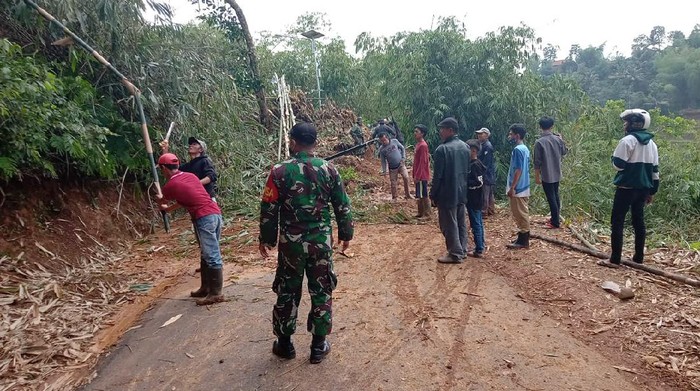 Petugas dan warga membersihkan material longsor di Sumedang.