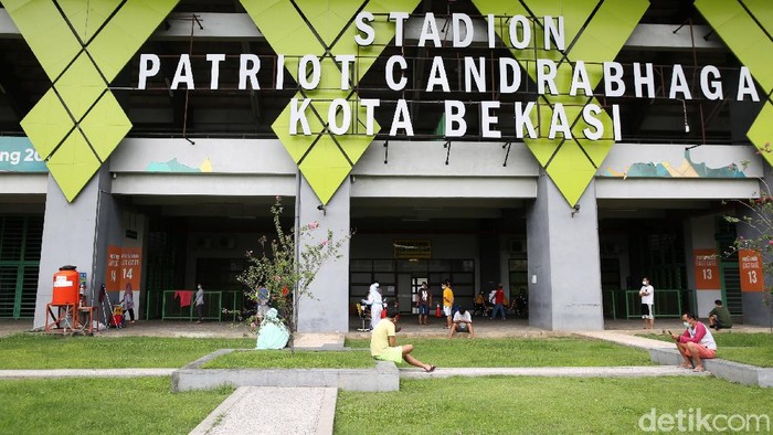 Petugas medis menggunakan Alat Pelindung Diri (APD) memeriksa kondisi pasien COVID-19 yang berstatus OTG (Orang Tanpa Gejala) saat kegiatan berjemur dan olahraga di Stadion Patriot Candrabhaga, Bekasi, Jawa Barat, Senin  (21/12/2020). Kegiatan pemeriksaan kesehatan, berjemur dan berolahraga tersebut rutin dilakukan setiap pagi hari untuk meningkatkan daya tahan tubuh pasien yang menjalani isolasi.