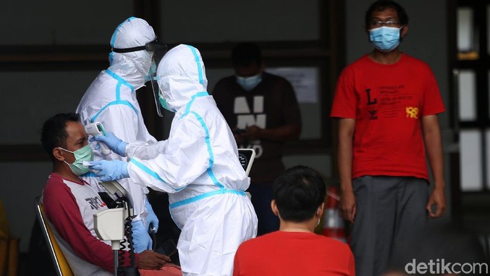Melihat Kegiatan Pasien OTG COVID-19 Petugas medis menggunakan Alat Pelindung Diri (APD) memeriksa kondisi pasien COVID-19 yang berstatus OTG (Orang Tanpa Gejala) saat kegiatan berjemur dan olahraga di Stadion Patriot Candrabhaga, Bekasi, Jawa Barat, Senin (21/12/2020). Kegiatan pemeriksaan kesehatan, berjemur dan berolahraga tersebut rutin dilakukan setiap pagi hari untuk meningkatkan daya tahan tubuh pasien yang menjalani isolasi.