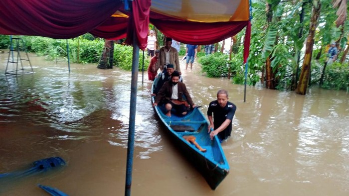 Penghulu di Maros terbos banjir pakai perahu demi nikahkan warga (Bakrie/detikcom).