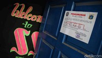 Kertas penyegelan ditempelkan di setiap pintu kafe ilegal tersebut.