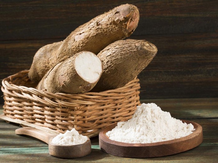 Singkong untuk kecantikan Raw cassava starch - Manihot esculenta. Wooden background
