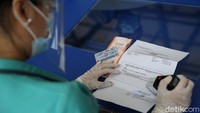 Seorang petugas mengecek surat keterangan hasil rapid test penumpang kereta api.