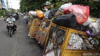 Terlihat sampah menumpuk dan berserakan hingga menutupi badan jalan di depan tempat pembuangan sampah sementara Pasar Lempuyangan, Kota Yogyakarta, Senin (21/12/2020).  