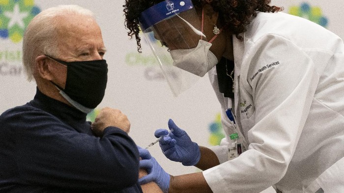 joe biden disuntik vaksin President-elect Joe Biden receives his first dose of the coronavirus vaccine from Nurse partitioner Tabe Mase at Christiana Hospital on live television in Newark Del., Monday, Dec. 21, 2020. (AP Photo/Carolyn Kaster)