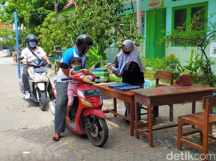 Pembagian rapor di sebuah Sekolah Dasar (SD) di Banyuwangi ini terbilang unik. Pembagian rapor dilakukan dengan sistem drive thru.