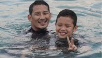 Bersama putranya Sulaiman saat berenang di Pantai Pemuteran, Bali. (sandiuno/Instagram)