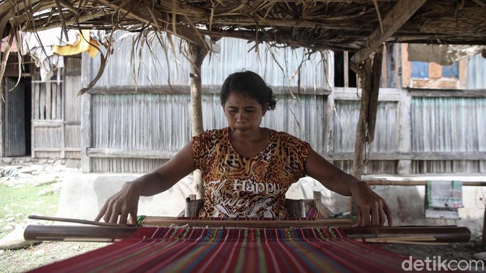 Magdalena Riwu, penenun asli Kabupaten Malaka tengah menenun di area pekarangan rumahnya, Malaka, Timor Tengah Selatan, NTT.