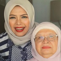 Ibu dari tiga anak ini kerap menggunakan hijab segiempat untuk sehari-hari. Seperti dalam foto ini, Mpok Nur yang berpose dengan sang ibunda, memakai bahan hijab voal rawis warna nude yang ia lilit rapi ke belakang.  Foto: Instagram @nurasiauno.