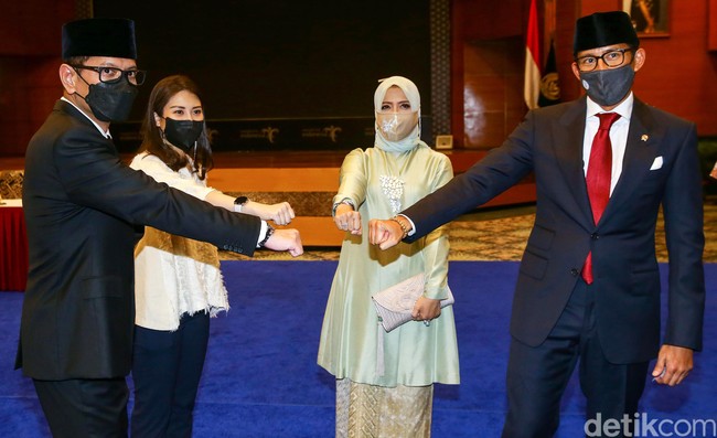 Sandiaga Uno resmi dilantik menjadi Menteri Pariwisata dan Ekonomi Kreatif (Menparekraf) oleh Presiden Jokowi. Dalam acara serah terima jabatan (Sertijab), tampak Nur Asia Uno atau akrab disapa Mpok Nur mendampingi. Ia memakai atasan bahan satin warna celery green dengan detail beads bagian dada dan bawahan kain songket. Foto: Grandyos Zafna.