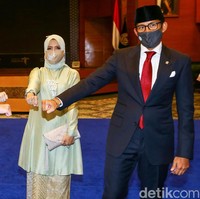 Sandiaga Uno resmi dilantik menjadi Menteri Pariwisata dan Ekonomi Kreatif (Menparekraf) oleh Presiden Jokowi. Dalam acara serah terima jabatan (Sertijab), tampak Nur Asia Uno atau akrab disapa Mpok Nur mendampingi. Ia memakai atasan bahan satin warna celery green dengan detail beads bagian dada dan bawahan kain songket. Foto: Grandyos Zafna.