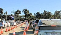 Warga diminta untuk melakukan tes sendiri tanpa petugas, menggunakan seperangkat alat tes yang diberikan lewat tongkat ke dalam mobil. Di dalam paket alat tes tersebut tersedia tata cara melakukan swab sendiri dan nantinya dikembalikan lagi ke petugas. Foto: Rengganis Pambudi
